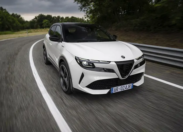 Alfa Romeo Junior en charge sur une borne électrique, vue urbaine